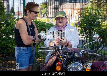 The Distinguished Gentleman's Ride (DGR) 2024. Dame auf Motorradkombination mit ihrem Jack Russell Stockfoto