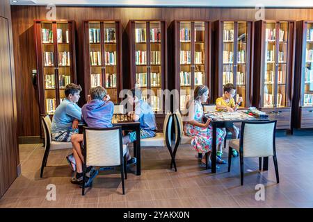 Triest Italien, Norwegian Cruise Line NCL Fluchtschiff, 10-tägige Mittelmeer-Adria Reiseroute, an Bord im Inneren, Jungen Mädchen, Brettspiele spielen, Stockfoto