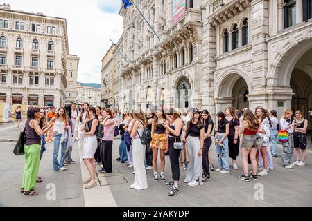 Triest Italien, Piazza della Borsa, Gruppe für Teenager Mädchen, Klassenschulausflug, Hörführer spricht, Palazzo della Borsa Vecchia, Old Stock Excha Stockfoto