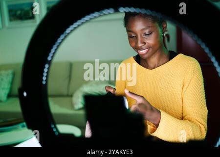 Eine junge Frau, die Inhalte erstellt, filmt ein Video mit einem Ringlicht in ihrem Heimstudio Stockfoto