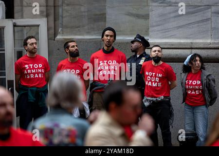 NEW YORK, NEW YORK - 14. OKTOBER: Verhaftete Demonstranten singen während eines pro-palästinensischen Sit-in vor der New Yorker Börse (NYSE) und protestierten gegen die anhaltende Unterstützung und Finanzierung Israels durch die Vereinigten Staaten in ihrem Krieg gegen die Hamas in Gaza am 14. Oktober 2024 in New York City. Der Protest wurde von Jewish Voice for Peace inszeniert, die sich als die größte fortschrittliche jüdische antizionistische Organisation der Welt bezeichnet, die häufig in den Vereinigten Staaten Proteste mit Massenverhaftungen auslöst. (Foto: Michael Nigro/SIPA USA) Stockfoto