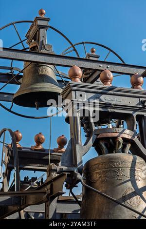 Komplizierte Kirchenglocken hängen in einem Metallrahmen vor blauem Himmel und zeigen Größe und Kunstfertigkeit Stockfoto