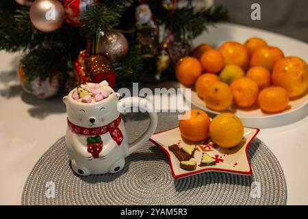 Festliche Weihnachtsszene mit einem niedlichen Eisbärenbecher auf einem dekorierten Tisch. Konzept mit gemütlichen Winterferien, saisonalen Leckereien und festlicher Atmosphäre Stockfoto