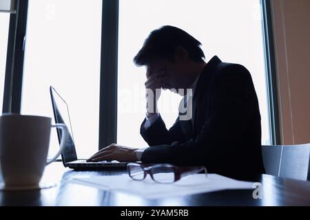 Gestresster, überarbeiteter Geschäftsmann im Büro. Stockfoto