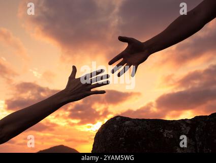 Eine helfende Hand auf einen Berg geben. Hilfe für jemanden in Not Konzept. Stockfoto