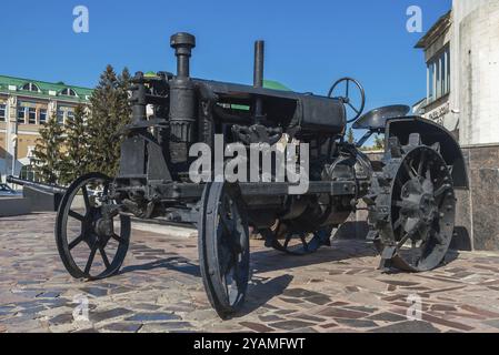 Alter schwarzer Traktor zum Pflügen eines Feldes (Anfang 20. Jahrhunderts hergestellt) Stockfoto