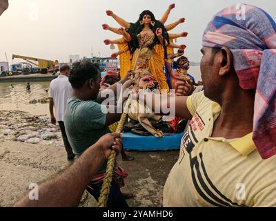 Nicht exklusiv: Devotees tauchen ein Idol der hinduistischen Göttin Durga in den Hootly Fluss während der Eintauchzeremonie von Durga Puja, die die letzte ist Stockfoto
