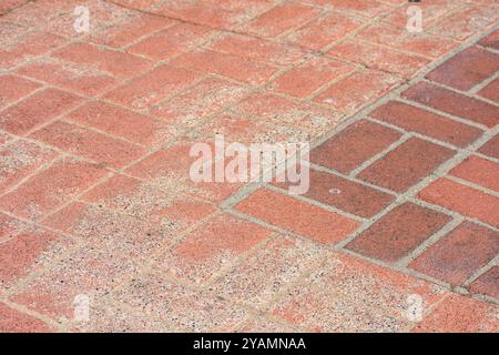 Nahaufnahme von rotem Ziegelpflaster mit einer Mischung aus verwitterten und neueren Ziegeln. Stockfoto