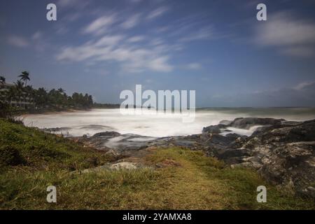 Strand, mit Lavasteinen und Vegetation, Blick auf das Meer am Abend bei Sonnenuntergang. Landschaft mit Wolken in Induruwa, Bentota Beach, Sri Lanka, Indien, A Stockfoto