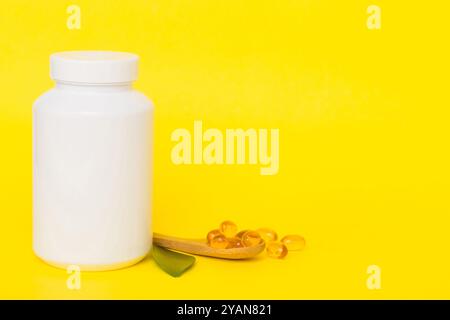 Omega-3 Kapseln liegen in einer weißen Flasche auf einem Tisch mit grünem Blatthintergrund. Fischöltabletten. Biologisch aktive Zusatzstoffe. omega 6, Omega 9, Vitam Stockfoto