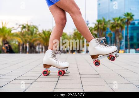 Schöne rothaarige junge Frau mit Rollerskates, die im Freien Spaß hat - hübsches weibliches Teenagermädchen mit einzigartigem Stil, das auf Rollschuhen in der fährt Stockfoto