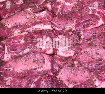 Hintergrund mariniertes Rindfleisch oder Schweinefleisch oder Hühnchenfleisch. Fleischhintergrund. Fleisch mit Gewürzen marinieren. Schweinefleisch- oder Rindfleischstücke zum Grillen, mariniert Stockfoto
