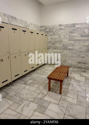 Ein stilvoller Umkleideraum mit Holzschränken, Schlössern und einer Sitzbank. Hochwertige Fotos Stockfoto