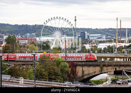 Neckarbrücken in Bad Cannstatt. Über die Eisenbahnbrücke Rosensteinbrücke rollt der Schienenverkehr, dahinter auf der König-Karls-Brücke fahren Autos und Stadtbahn. Dahinter das Cannstatter Volksfest und der Hauptspitz der Mercedes-Benz Group AG in Untertürkheim. // 09.10.2024: Stuttgart, Baden-Württemberg, Deutschland, Europa *** Neckarbrücken in Bad Cannstatt der Eisenbahnverkehr rollt über die Rosensteinbrücke, Autos und Stadtbahn dahinter auf der König-Karls-Brücke dahinter das Cannstatter Volksfest und der Hauptsitz der Mercedes Benz Group AG in Untertürkheim 09 10 2024 Stuttga Stockfoto