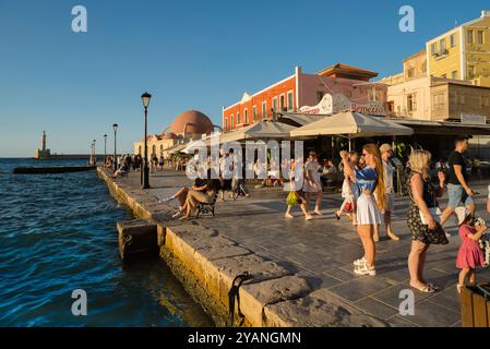 Chania Kreta, Blick bei Sonnenuntergang auf Menschen, die in der malerischen venezianischen Hafengegend in der historischen Altstadt von Chania (Hania), Kreta, Griechenland, spazieren gehen Stockfoto