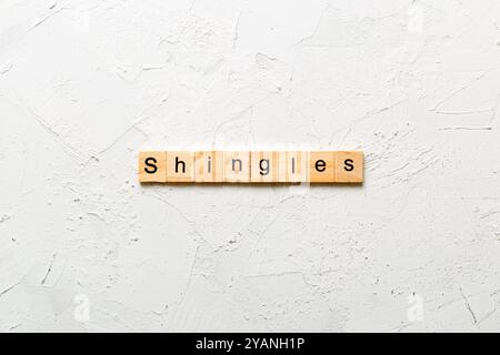 Schindeln Wort auf Holzblock geschrieben. Schindeln Text auf Zementtisch für Ihr Design, Konzept. Stockfoto