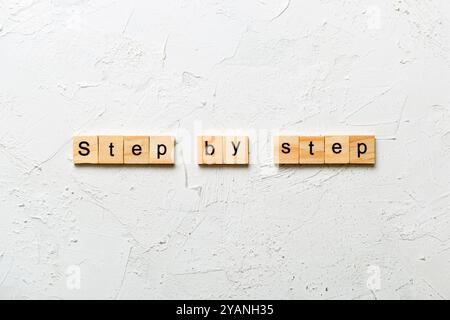 Schritt für Schritt Wort auf Holzblock geschrieben. Schritt für Schritt Text auf Tabelle, Konzept. Stockfoto