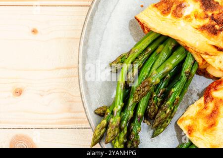 Ei-Omelett mit grünem Spargel auf rustikalem Holztisch gekocht. Kopierbereich Stockfoto