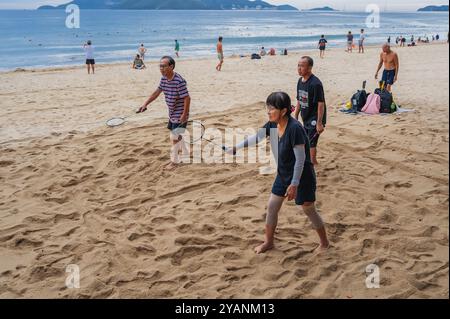 Ältere alte asiatische pensionierte Spieler spielen Strandbadminton mit Schlägern am Strand am Meer im Sommer im Urlaub in Asien. Nha Trang, Vietnam - 6. September 2024 Stockfoto