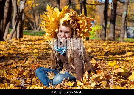 Zehn Jahre altes Mädchen genießt Herbstlaub in einem Park Stockfoto