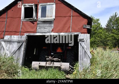 Alte Schuppen auf einem Plattenbauernhof im ländlichen Ontario mit Maschinen Stockfoto