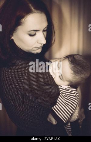 Das Baby schlief in den Händen der Mutter ein Stockfoto