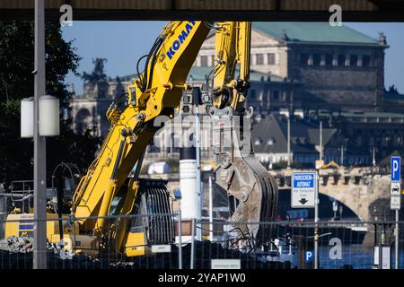 Dresden, Deutschland. Oktober 2024. Bagger entfernen Trümmer von der eingestürzten Carolabrücke-Brücke auf der Altstadtseite der Elbe; im Hintergrund ist die Semperoper zu sehen. Der westliche Abschnitt der Brücke mit Straßenbahnschienen, Radweg und Fußweg brach in der Nacht vom 11. September 2024 aus unbekannten Gründen zusammen. Robert Michael/dpa/Alamy Live News Stockfoto