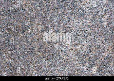 Nahaufnahme natürlicher Granitstein-Textur mit detaillierter Körnung und subtilen Farbvariationen. Konzept der Rohstoffe, Geologie und strukturierten Hintergründe Stockfoto