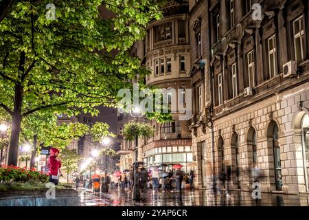 Belgrad, Serbien - 25. September 2015: Menschen, die in der Knez-Mihailova-Straße in Belgrad bei regnerischer Nacht spazieren gehen Stockfoto