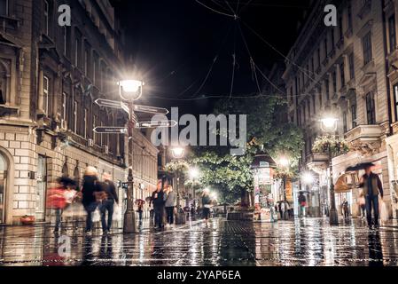 Belgrad, Serbien - 25. September 2015: Menschen, die nachts auf der belebten Straße Knez Mihailova spazieren, mit Lichtern, die auf nassem Kopfsteinpflaster nach der r Stockfoto