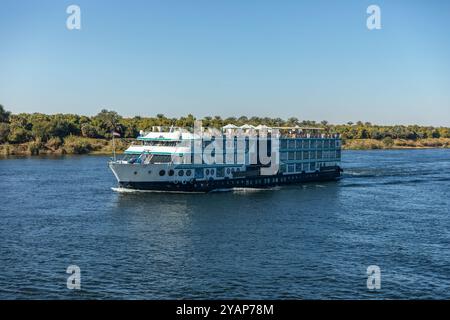 Assuan, Ägypten; 17. Januar 2024: Stellen Sie sich vor, Sie segeln den Nil hinunter als ein alter Pharao, umgeben von einer Flotte von Feluken. Entdecken. Stockfoto