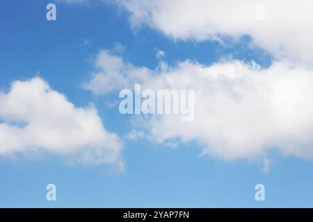 Ein wunderschöner heller blauer Himmel voller flauschiger weißer Wolken, die anmutig darüber schweben Stockfoto