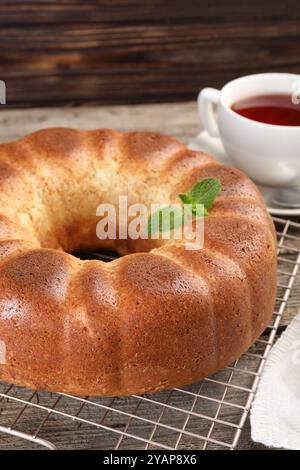 Frisch gebackener Biskuitkuchen und Tee auf Holztisch, Nahaufnahme Stockfoto