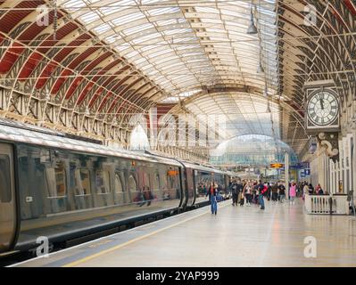 Menschen, die einen GWR-Zug auf dem Bahnsteig in Paddington Station, London, UK, besteigen Stockfoto