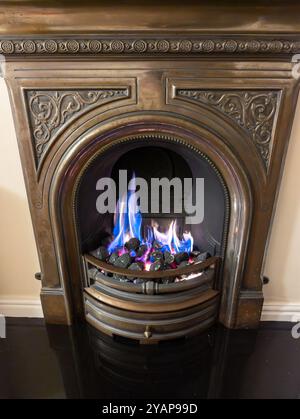 Künstliche Kohlehaushalt-Gasfeuer brennt im Kamin Stockfoto