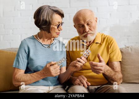 Eine fürsorgliche Frau hilft ihrem Mann, seine Diabetes-Medikamente zu überprüfen, während sie zusammen sitzt. Stockfoto
