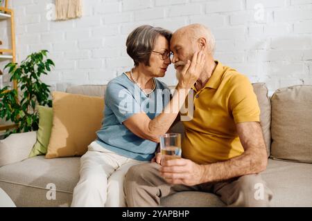 Eine hingebungsvolle Ehefrau unterstützt ihren Mann zu Hause liebevoll, während sie seinen Diabetes gemeinsam verwaltet. Stockfoto