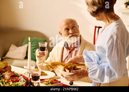 Ein fröhliches Seniorenpaar genießt ein herrliches Weihnachtsessen zusammen. Stockfoto