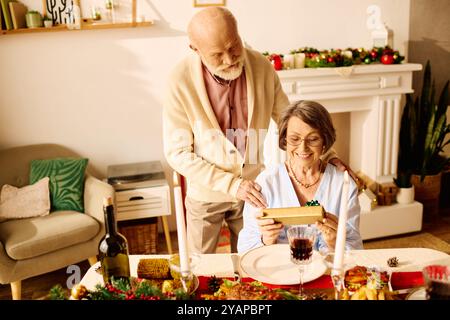 Ein liebevolles Seniorenpaar genießt zu Hause einen festlichen Weihnachtstag, öffnet Geschenke und lächelt. Stockfoto
