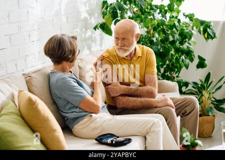 Ein älteres Paar teilt einen zärtlichen Moment, als die Frau ihrem Mann hilft, seinen Diabetes zu bewältigen. Stockfoto