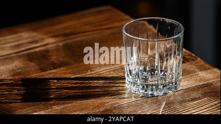 Ein einziges leeres Glas auf einem Tisch. Stockfoto