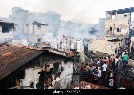 Manila, Philippinen. Oktober 2024. Die Bewohner kehren nach einem Brand in einem Slumgebiet in Manila, den Philippinen, am 15. Oktober 2024 in ihre verkohlten Häuser zurück. Quelle: Rouelle Umali/Xinhua/Alamy Live News Stockfoto