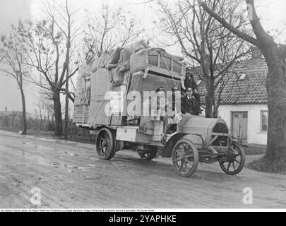 Ein voll beladener LKW. Vor einem Haus steht ein Lastwagen der Firma Malmö Stadsbud und ist voll beladen mit zu transportierenden Haushaltsgütern. Möbel und Kisten sind gut verpackt und mit Seilen verzurrt. Der alte Ford-Lkw hat massive Gummiräder und Platz für drei Personen, die auf dem Sitz sitzen. Ein Schild auf dem LKW steht für den Namen des Unternehmens, dem die Umzugsgesellschaft Stadsbudsföreningen Nr. 2 Malmö 1920s gehört Stockfoto