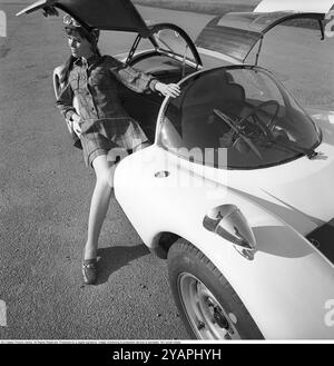 Porsche Juni 1967. Ein Modell, das auf einem Porsche 906 in der Mode des Jahres gekleidet ist. Das Rennwagenmodell wurde 1966 auf den Markt gebracht und wird auch Porsche Carrera 6 genannt. Das Auto hatte Autotüren, genannt GullFlügeltüren, eine Art von Autotür, die sich nach oben öffnet. Insgesamt wurden 50 Exemplare des Autos produziert, die unter anderem vom schwedischen Rennfahrer Sten Axelsson im Motorsport eingesetzt wurden. Foto mit Hasselblad Stockfoto