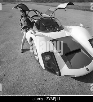 Porsche Juni 1967. Ein Modell, das auf einem Porsche 906 in der Mode des Jahres gekleidet ist. Das Rennwagenmodell wurde 1966 auf den Markt gebracht und wird auch Porsche Carrera 6 genannt. Das Auto hatte Autotüren, genannt GullFlügeltüren, eine Art von Autotür, die sich nach oben öffnet. Insgesamt wurden 50 Exemplare des Autos produziert, die unter anderem vom schwedischen Rennfahrer Sten Axelsson im Motorsport eingesetzt wurden. Foto mit Hasselblad Stockfoto