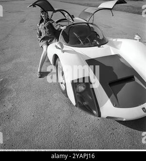 Porsche Juni 1967. Ein Modell, das auf einem Porsche 906 in der Mode des Jahres gekleidet ist. Das Rennwagenmodell wurde 1966 auf den Markt gebracht und wird auch Porsche Carrera 6 genannt. Das Auto hatte Autotüren, genannt GullFlügeltüren, eine Art von Autotür, die sich nach oben öffnet. Insgesamt wurden 50 Exemplare des Autos produziert, die unter anderem vom schwedischen Rennfahrer Sten Axelsson im Motorsport eingesetzt wurden. Foto mit Hasselblad Stockfoto