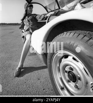 Porsche Juni 1967. Ein Modell, das auf einem Porsche 906 in der Mode des Jahres gekleidet ist. Das Rennwagenmodell wurde 1966 auf den Markt gebracht und wird auch Porsche Carrera 6 genannt. Das Auto hatte Autotüren, genannt GullFlügeltüren, eine Art von Autotür, die sich nach oben öffnet. Insgesamt wurden 50 Exemplare des Autos produziert, die unter anderem vom schwedischen Rennfahrer Sten Axelsson im Motorsport eingesetzt wurden. Foto mit Hasselblad Stockfoto