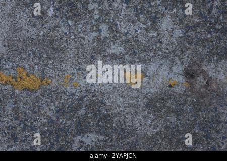 Die Beschaffenheit einer Asphaltstraße, mit einem abgenutzten gelben Streifen Farbe. Der Straßenhintergrund. Stock Foto Stockfoto