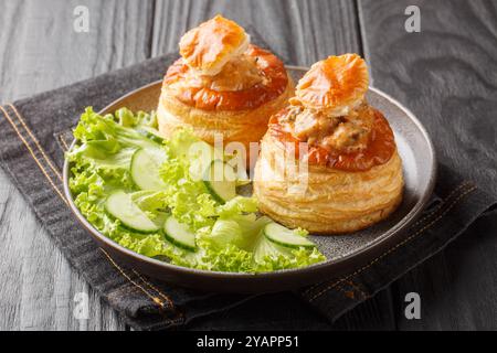 Köstlicher klassischer Bouchee vol-au-Vent gefüllt mit Rindereintopf in einem Teller auf einem Holztisch. Horizontal Stockfoto