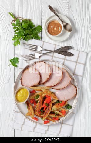 Schupfnudeln, Fingernudeln, Kartoffeldicknudeln, Knödel mit Senf und Sous-Vide-Schweinelende auf einem Teller auf weißem Holztisch mit Gabel geschnitten Stockfoto